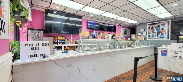 a store room with stainless steel appliances granite countertop a sink and cabinets