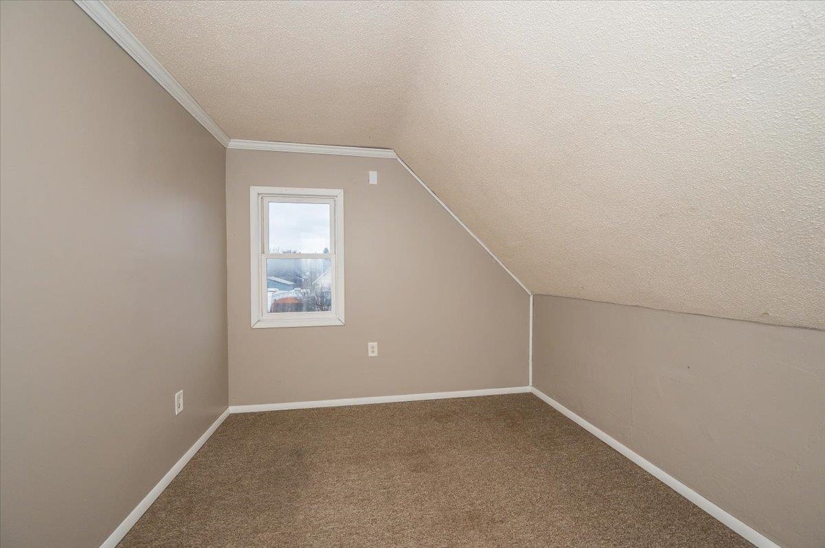 3701 East 2nd Street Superior, WI 54880 - Photo 14 of 25 Additional living space featuring dark carpet, a textured ceiling, and lofted ceiling