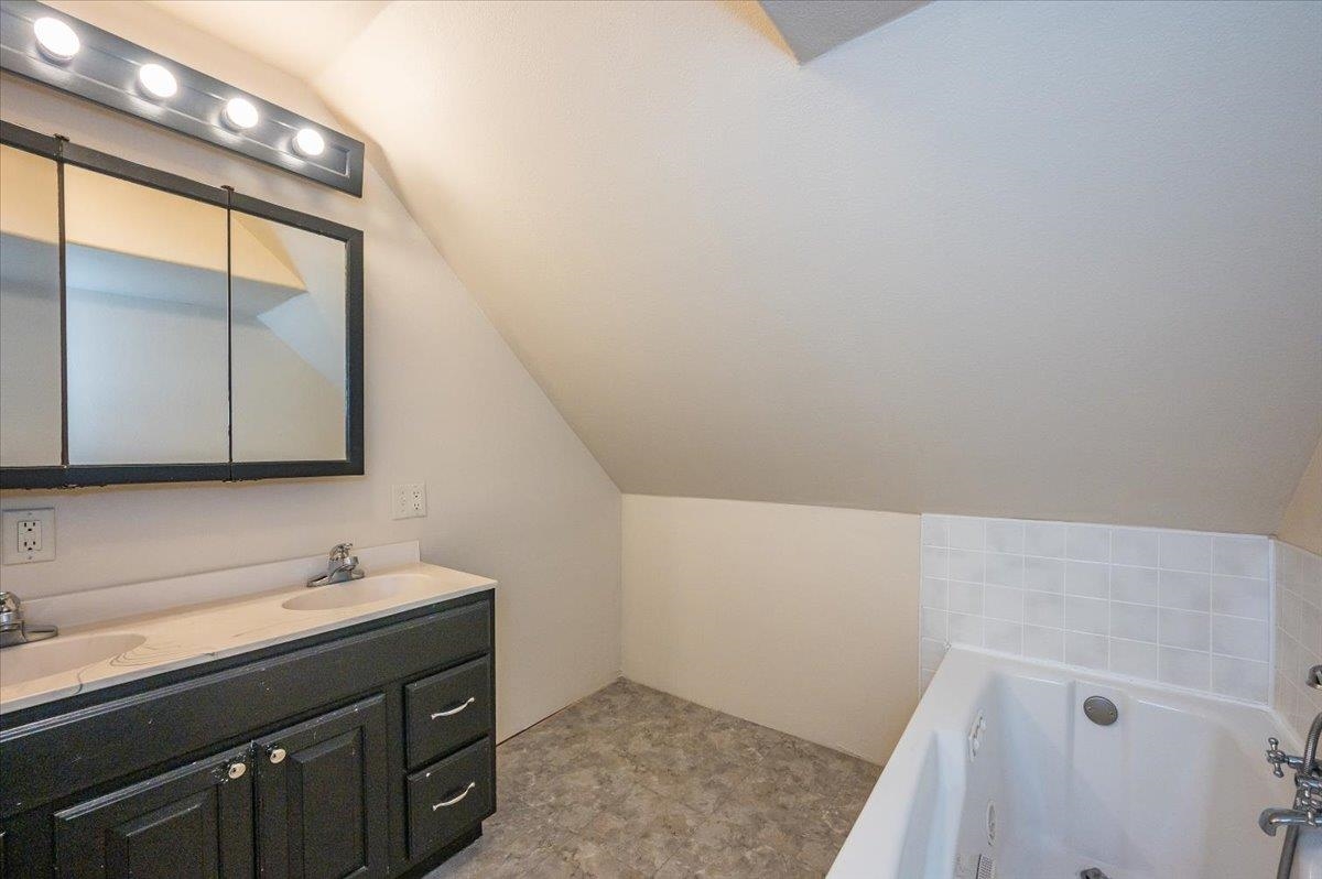 3701 East 2nd Street Superior, WI 54880 - Photo 16 of 25 Bathroom with lofted ceiling, a garden tub, and double vanity