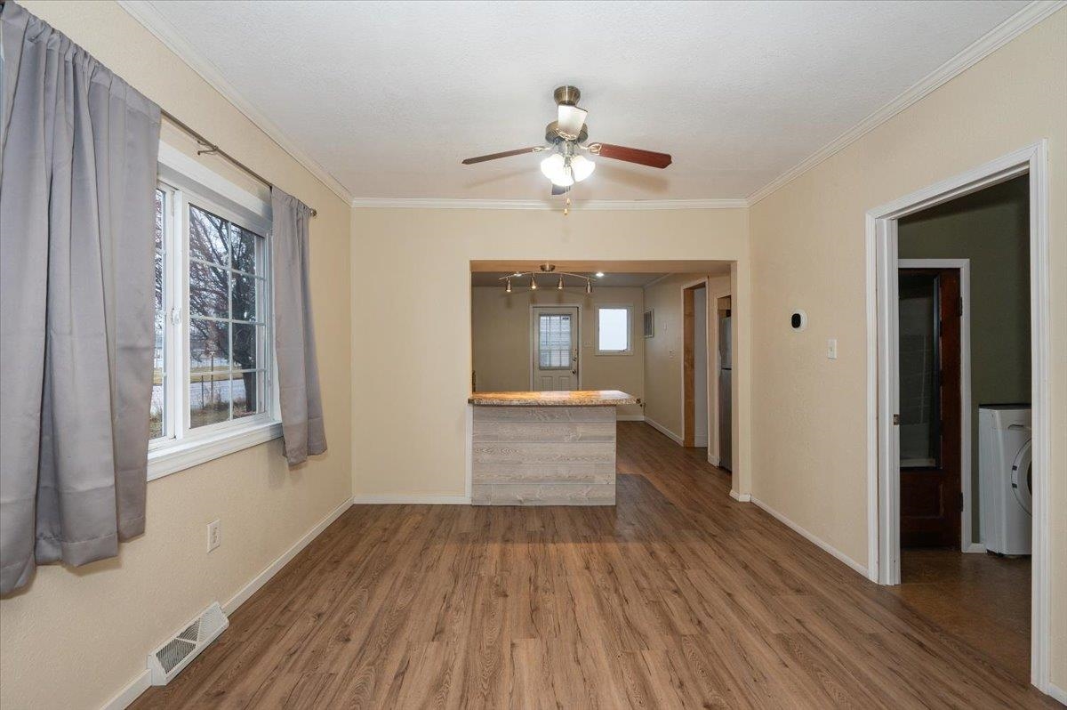 3701 East 2nd Street Superior, WI 54880 - Photo 5 of 25 Unfurnished dining room featuring vinyl plank flooring, crown molding, ceiling fan.