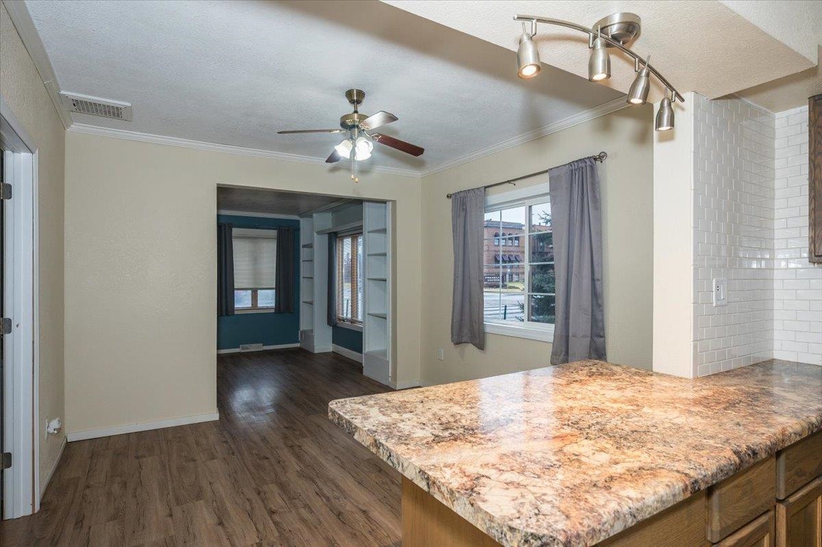 3701 East 2nd Street Superior, WI 54880 - Photo 6 of 25 Kitchen featuring dark wood-type flooring, a ceiling fan, a textured ceiling, ornamental molding, and a peninsula