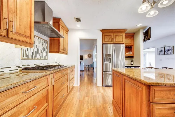 a large kitchen with stainless steel appliances granite countertop a lot of counter space and wooden floor