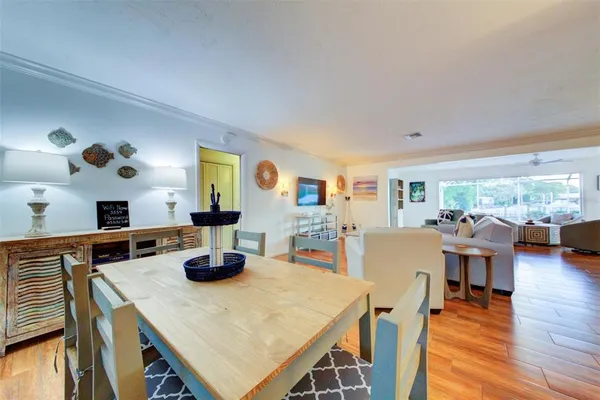 a dining room with wooden floor and large windows