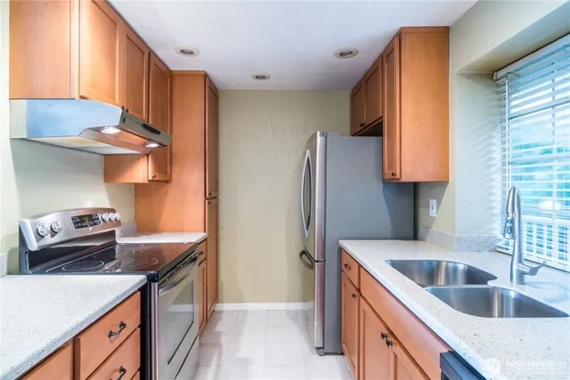 a kitchen with stainless steel appliances granite countertop a sink stove and refrigerator