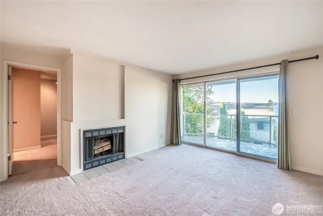 a view of an empty room with a fireplace and a window