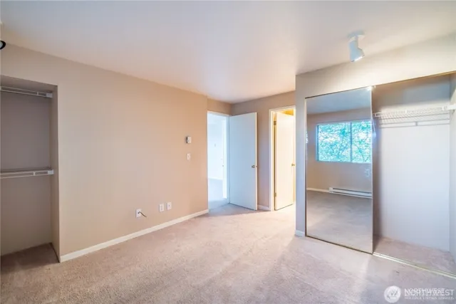 an empty room with windows and closet