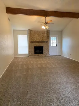 a view of empty room with a fireplace and fan