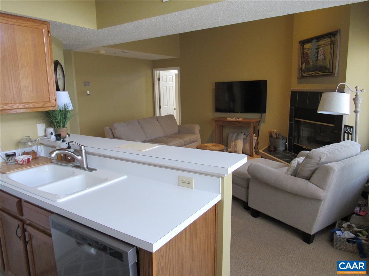 2002 Stone Rdg Wds, Unit 2002 Wintergreen, VA 22967 - Photo 3 of 22 a living room with stainless steel appliances furniture a flat screen tv and a kitchen view