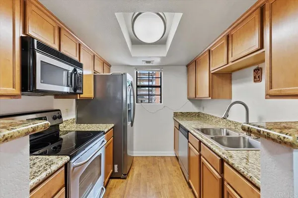a kitchen with stainless steel appliances granite countertop a sink stove and refrigerator