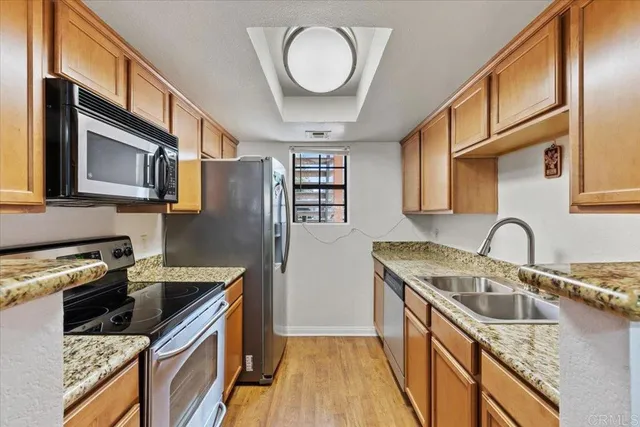 a kitchen with stainless steel appliances granite countertop a sink stove and refrigerator