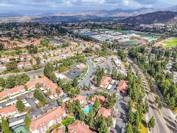 an aerial view of residential house with yard and mountain view in back