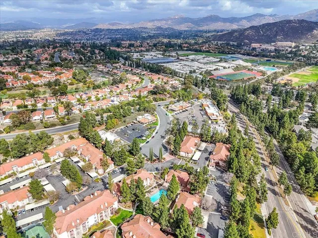 an aerial view of residential house with yard and mountain view in back