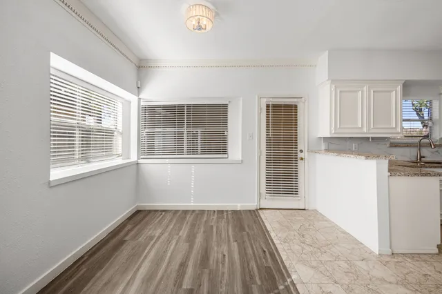 a view of a kitchen with wooden floor and windows