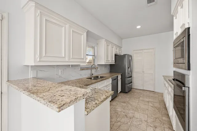 a kitchen with stainless steel appliances granite countertop a sink stove and refrigerator