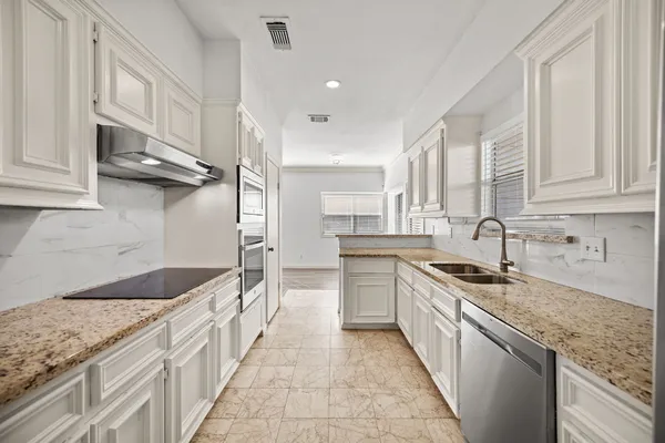 a kitchen with stainless steel appliances granite countertop a sink stove and cabinets