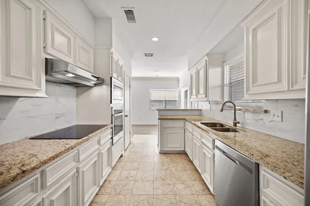a kitchen with stainless steel appliances granite countertop a sink stove and cabinets