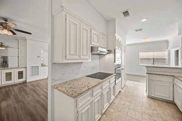 a kitchen with stainless steel appliances kitchen island granite countertop a sink and cabinets