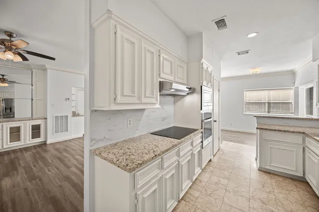 a kitchen with stainless steel appliances kitchen island granite countertop a sink and cabinets