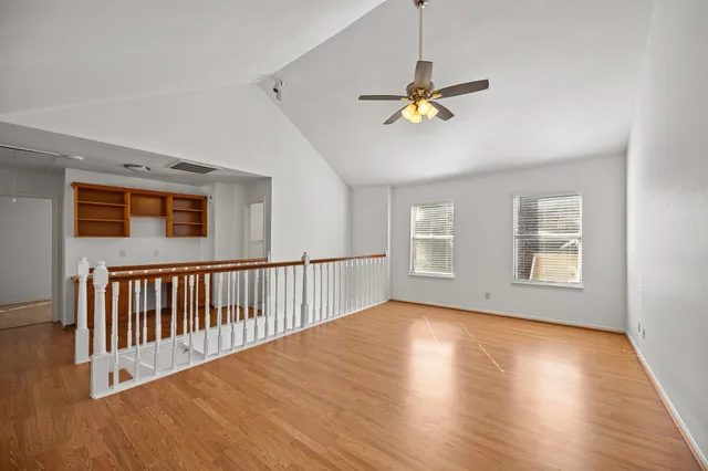 a view of a livingroom with wooden floor and a ceiling fan