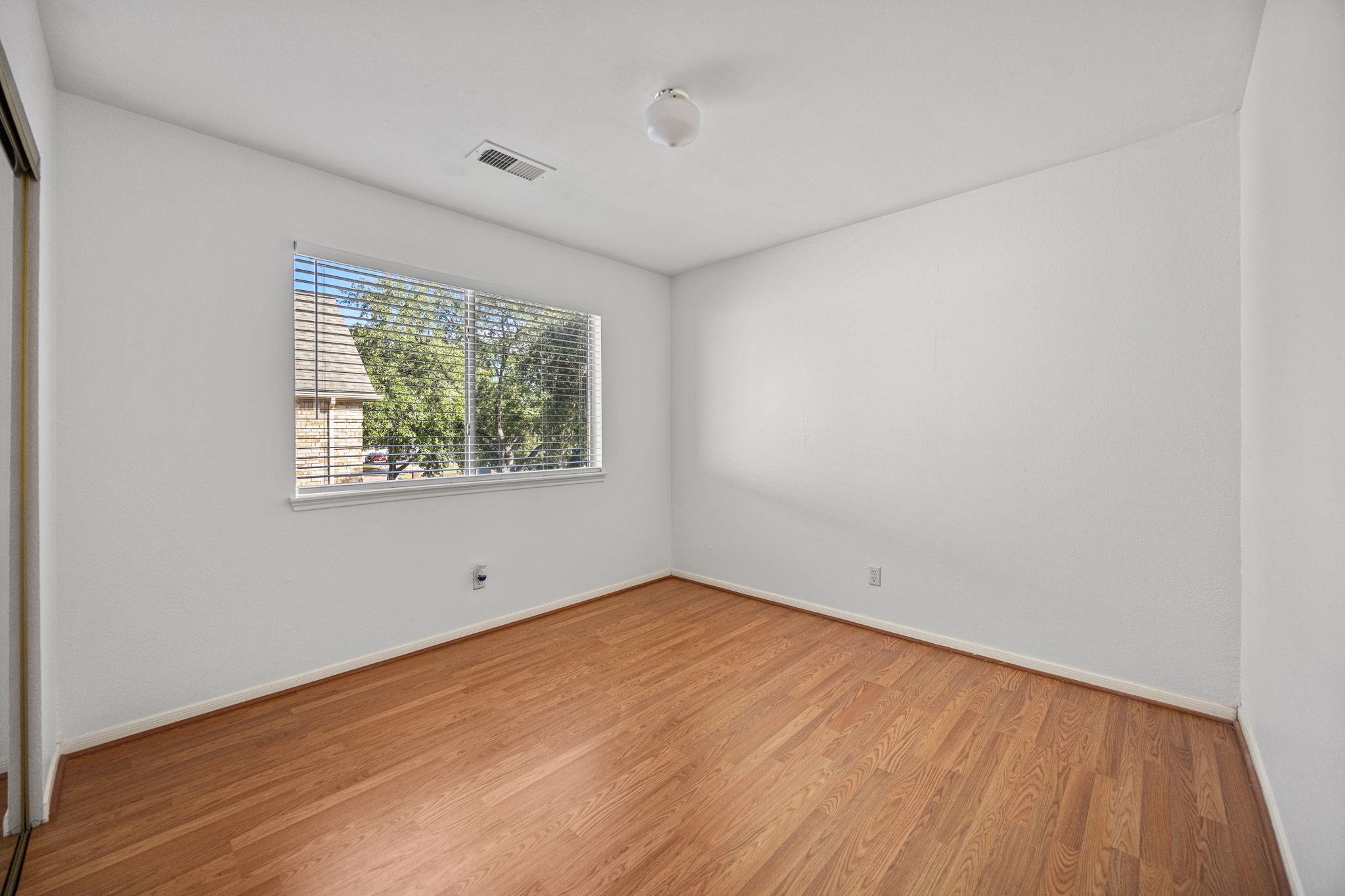 8043 Oceanside Drive Houston, TX 77095 - Photo 25 of 41 an empty room with wooden floor and windows