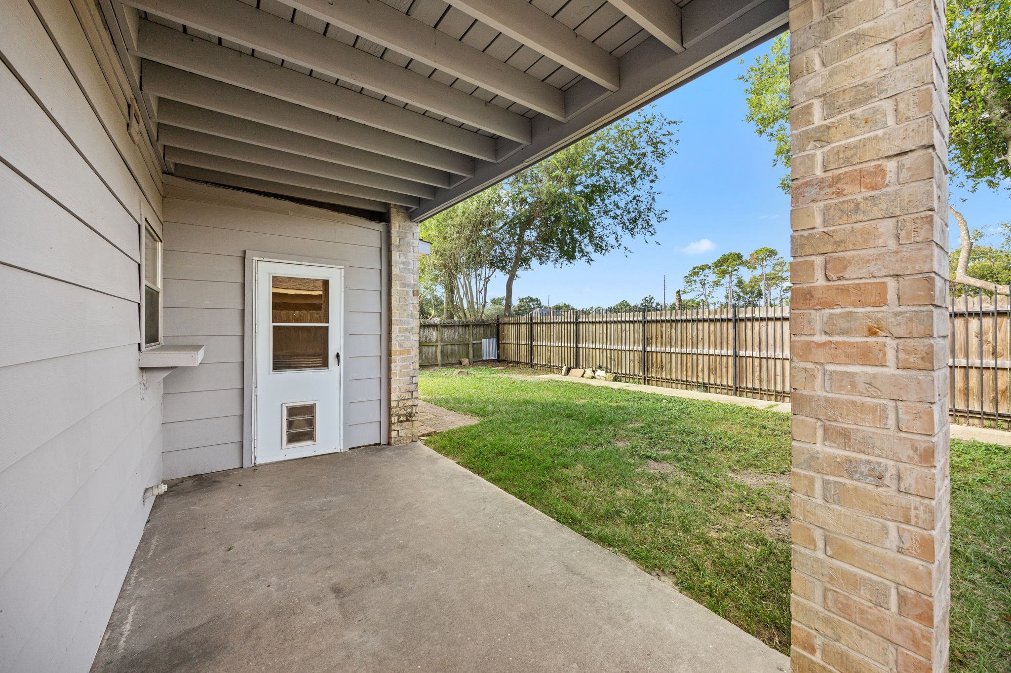 8043 Oceanside Drive Houston, TX 77095 - Photo 29 of 41 a view of a backyard with wooden fence and a floor to ceiling window