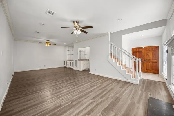 a view of a livingroom with wooden floor and a ceiling fan