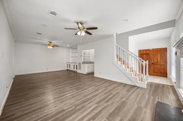 a view of a livingroom with wooden floor and a ceiling fan