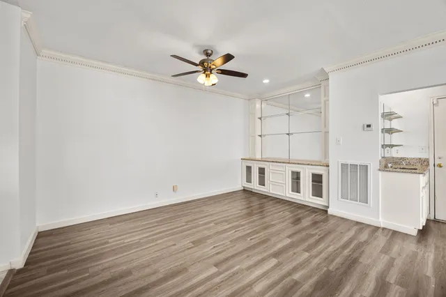 a view of a room with wooden floor and a ceiling fan