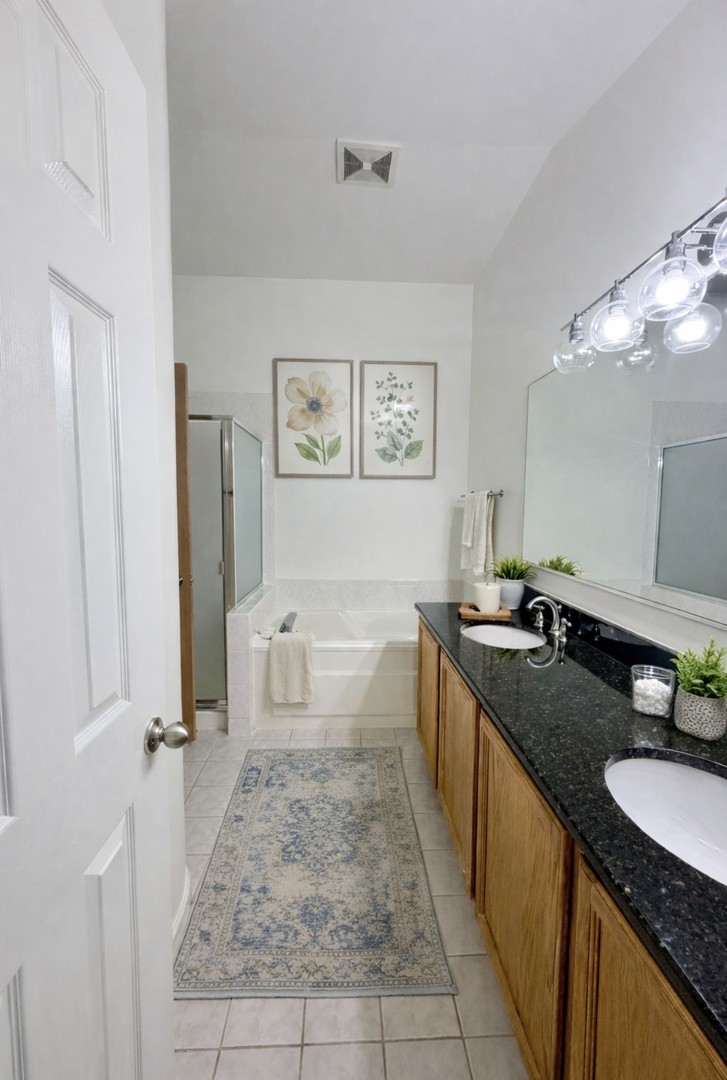 4 Haverton Court Streamwood, IL 60107 - Photo 24 of 30 a spacious bathroom with a granite countertop sink a toilet a mirror and shower