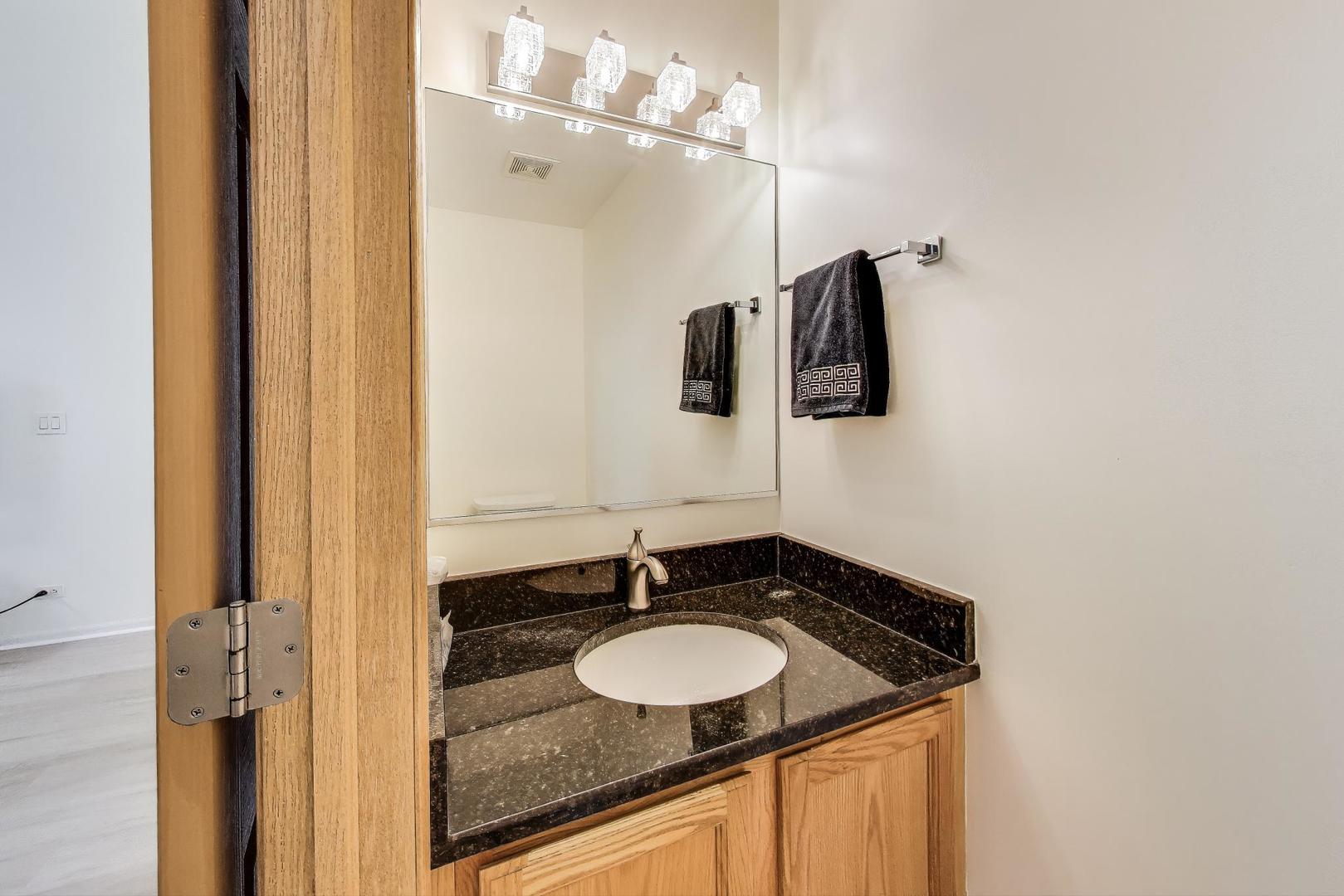 4 Haverton Court Streamwood, IL 60107 - Photo 7 of 30 a bathroom with a granite countertop sink and a mirror