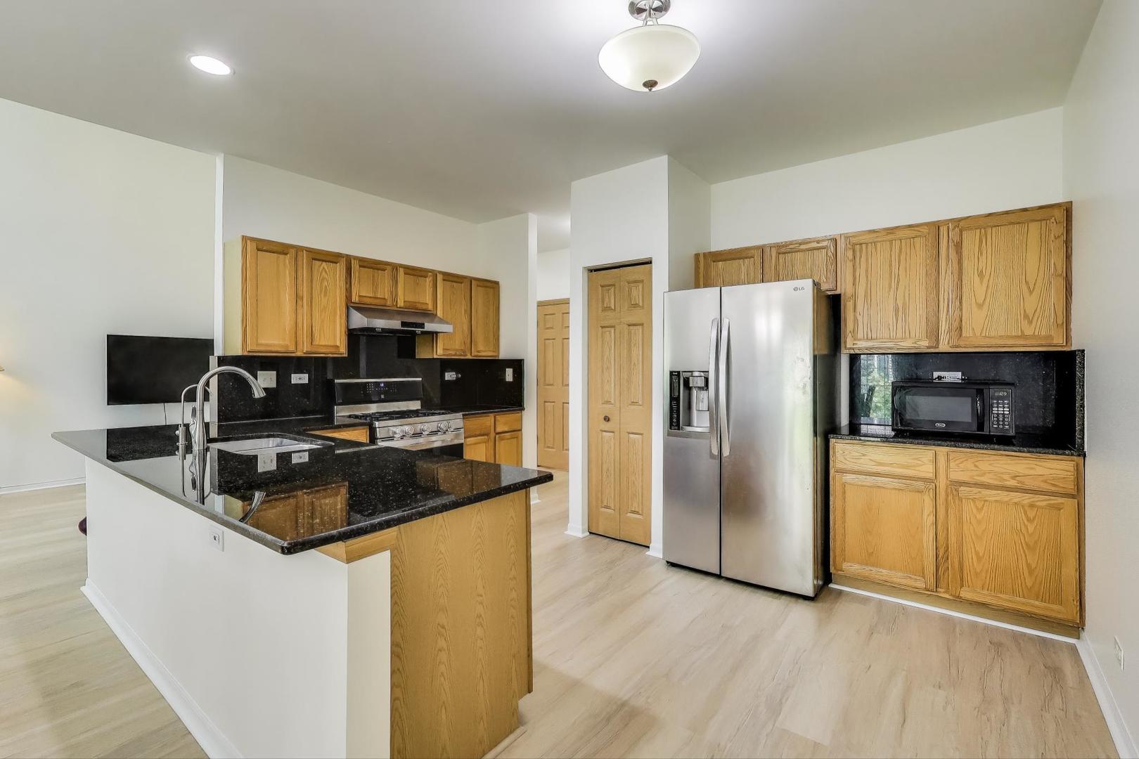 4 Haverton Court Streamwood, IL 60107 - Photo 10 of 30 a kitchen with stainless steel appliances granite countertop a refrigerator a stove a sink a microwave and a refrigerator