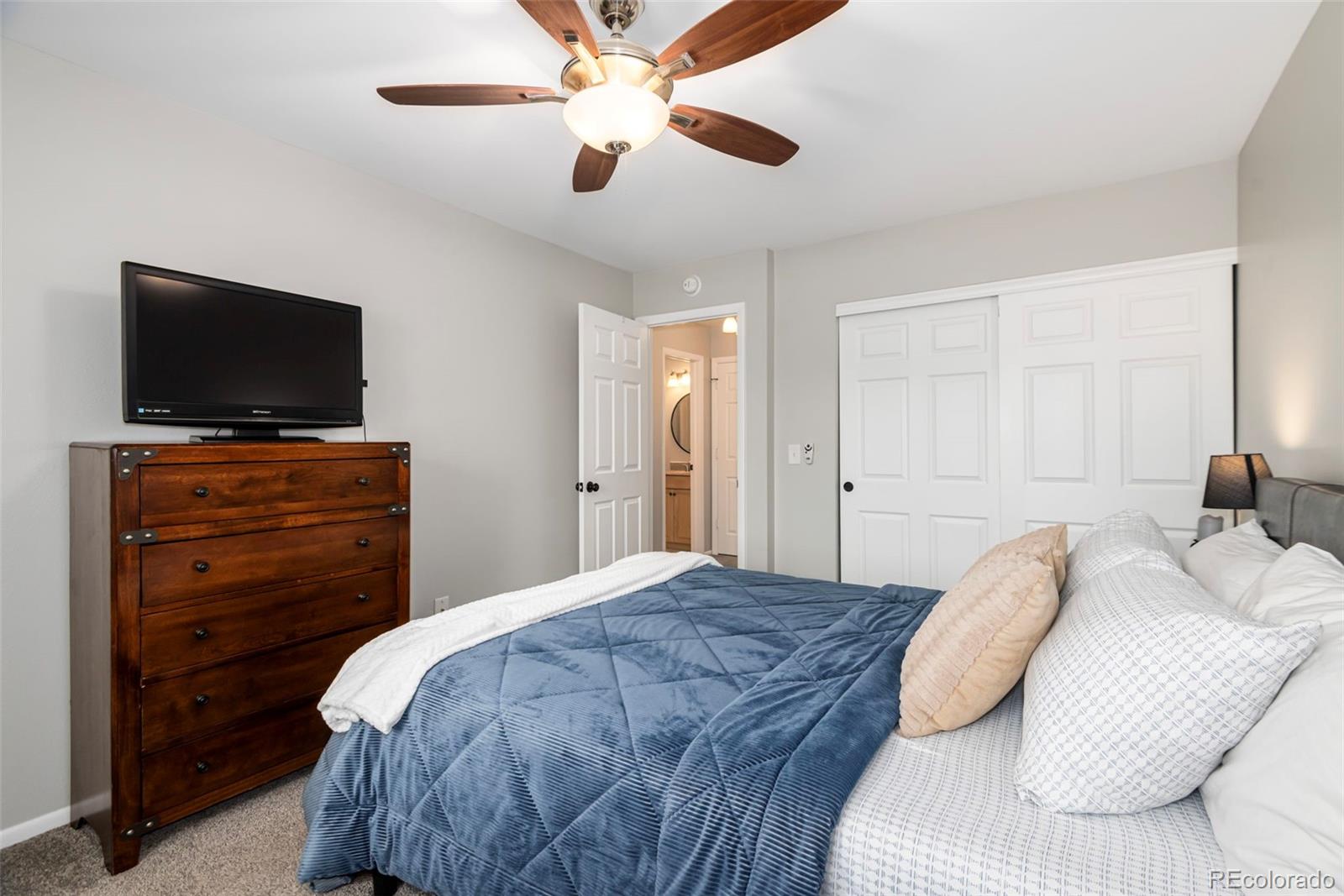8751 Chase Drive, Unit 181 Arvada, CO 80003 - Photo 14 of 25 a bedroom with a bed and a flat screen tv
