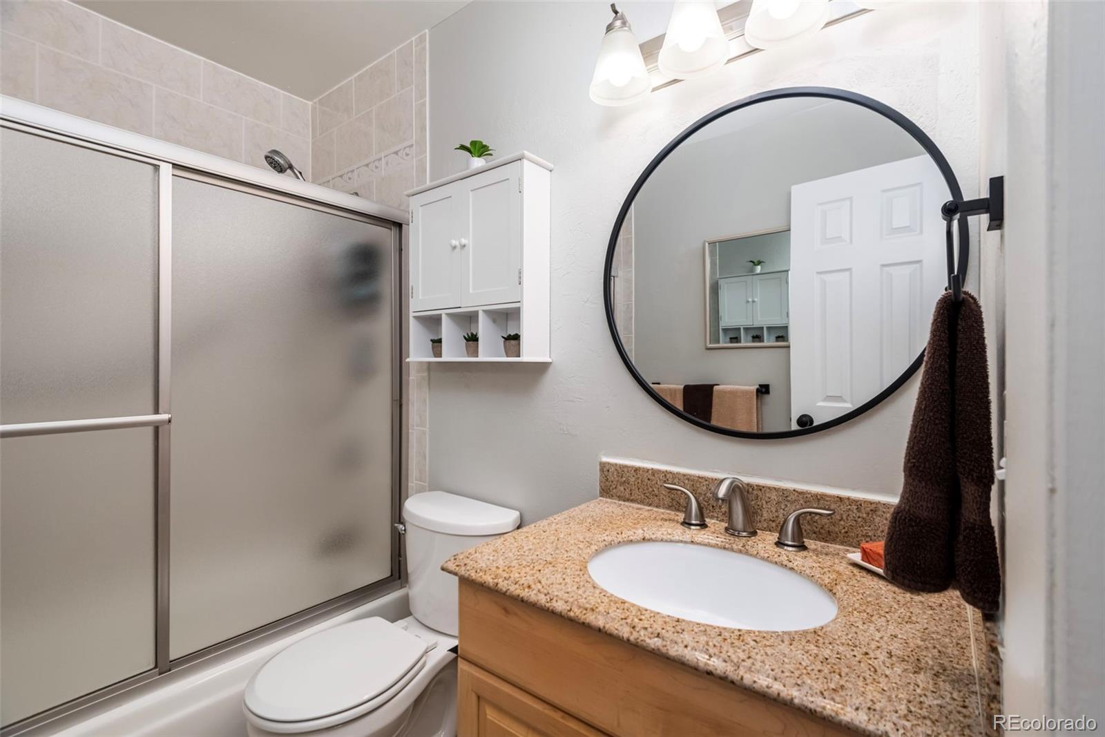 8751 Chase Drive, Unit 181 Arvada, CO 80003 - Photo 15 of 25 a bathroom with a granite countertop sink mirror vanity and toilet