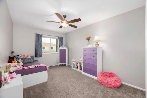 a bedroom with furniture and a chandelier fan