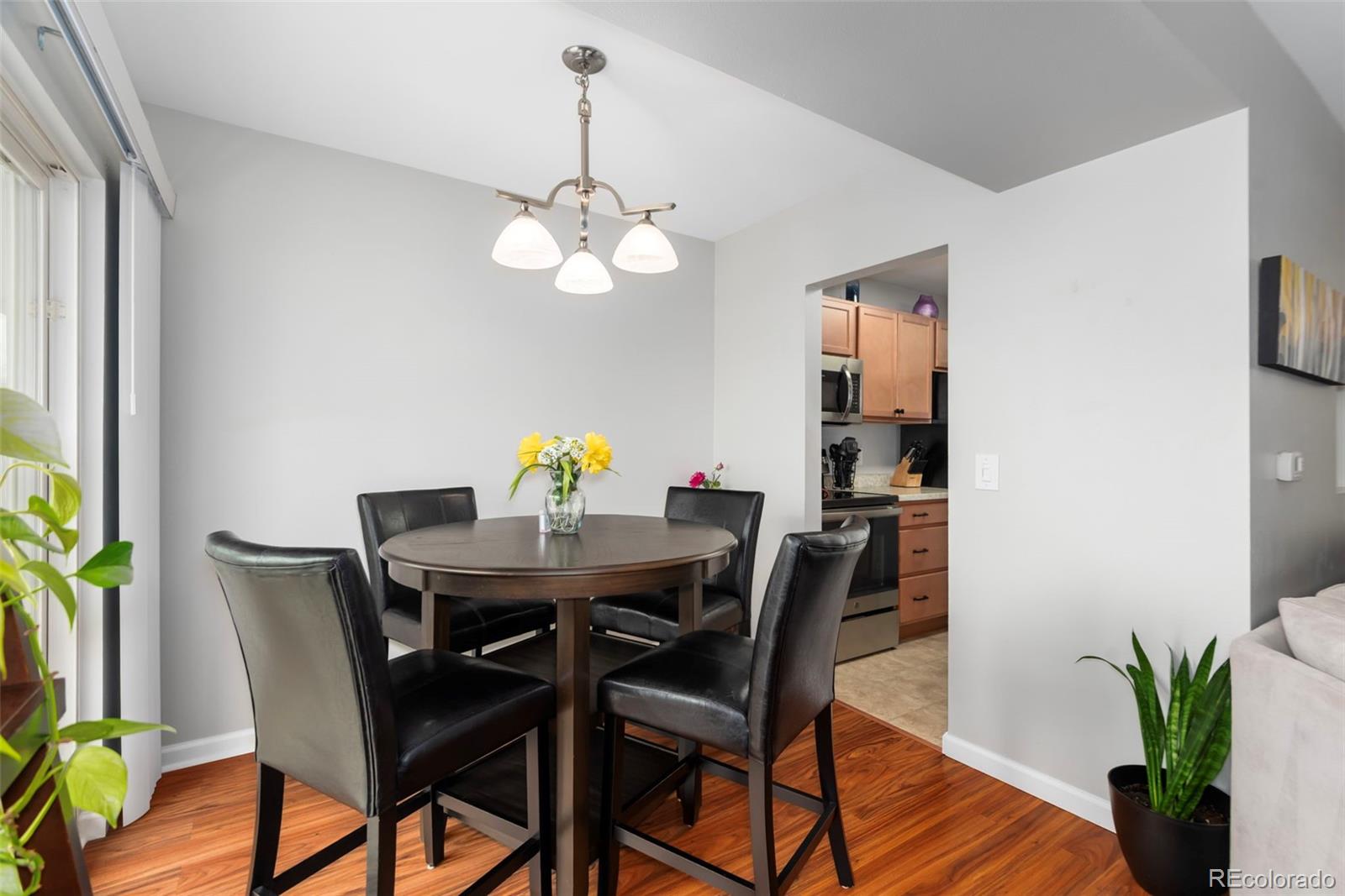 8751 Chase Drive, Unit 181 Arvada, CO 80003 - Photo 5 of 25 a view of a dining room with furniture wooden floor and chandelier
