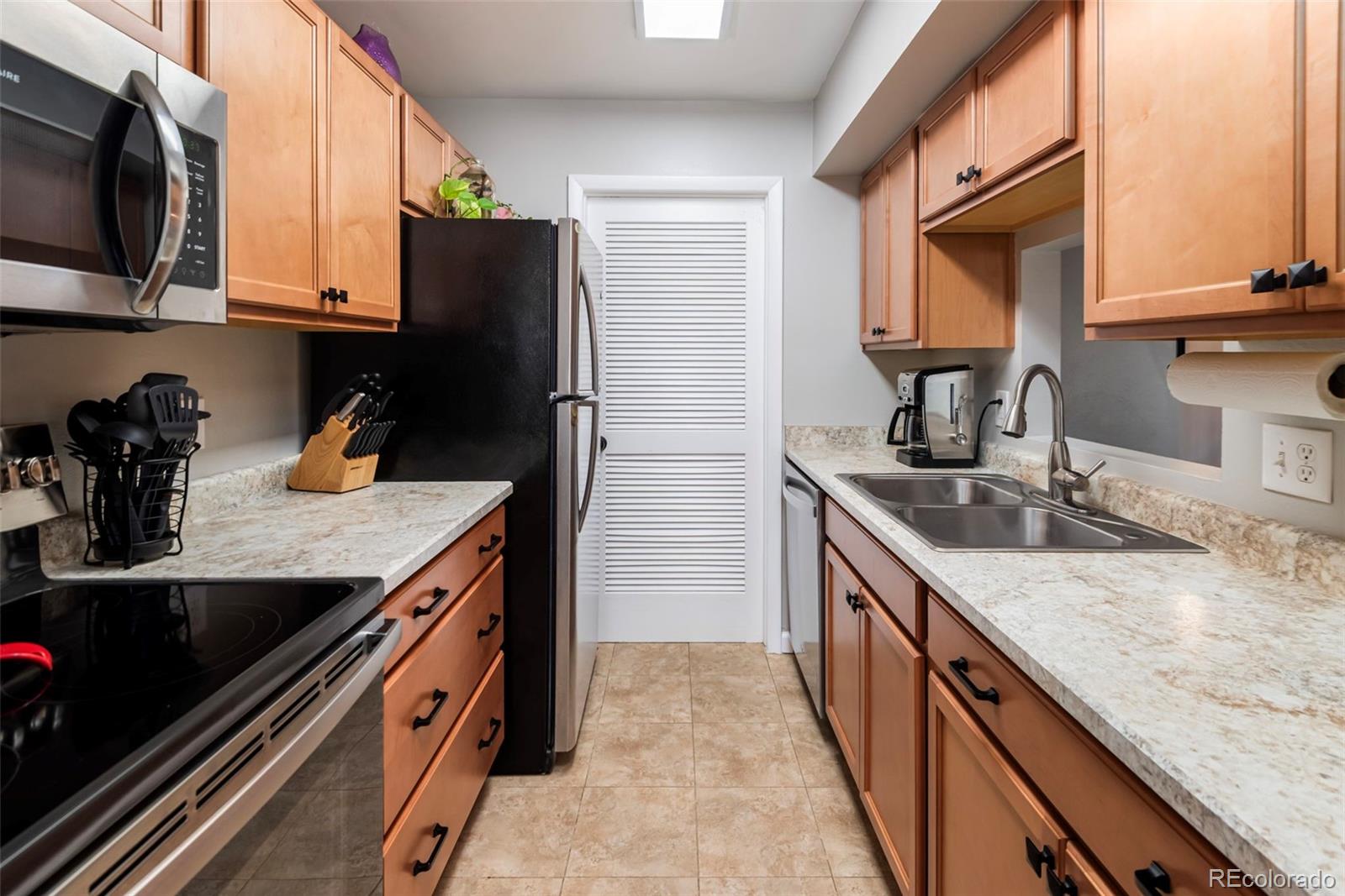 8751 Chase Drive, Unit 181 Arvada, CO 80003 - Photo 8 of 25 a kitchen with granite countertop stainless steel appliances and wooden cabinets