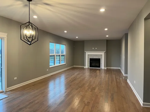 a view of empty room with wooden floor and fireplace
