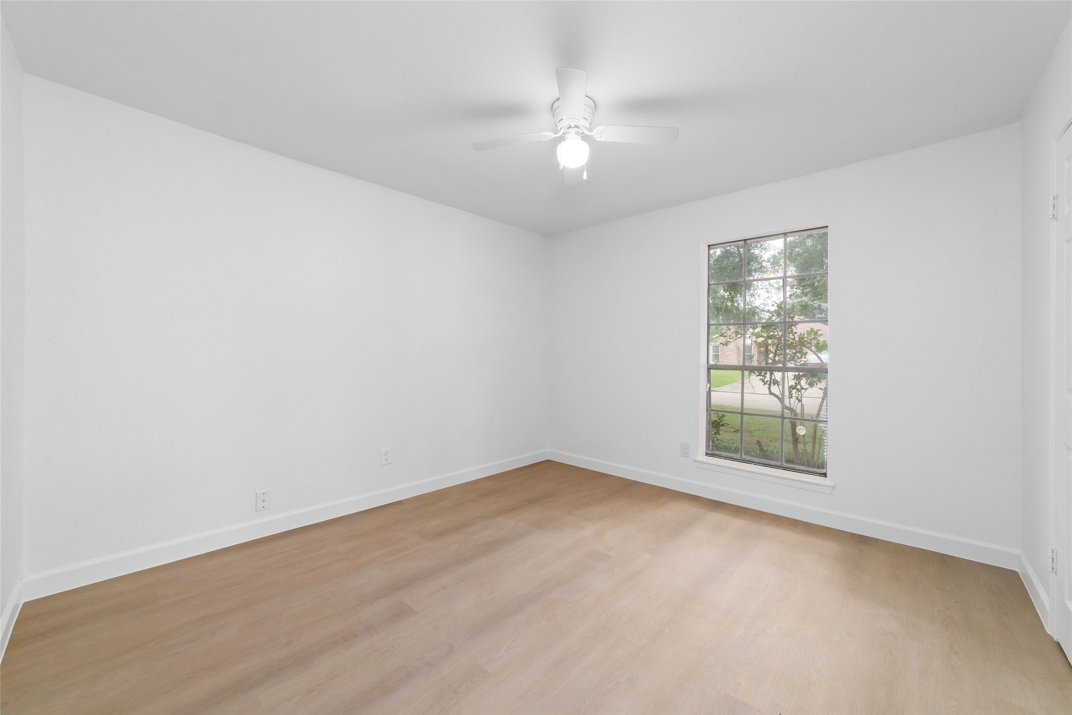 5023 Monteith Drive Spring, TX 77373 - Photo 15 of 20 Light-filled bedroom featuring a ceiling fan and a large window that frames outdoor views, creating a calm and inviting space.