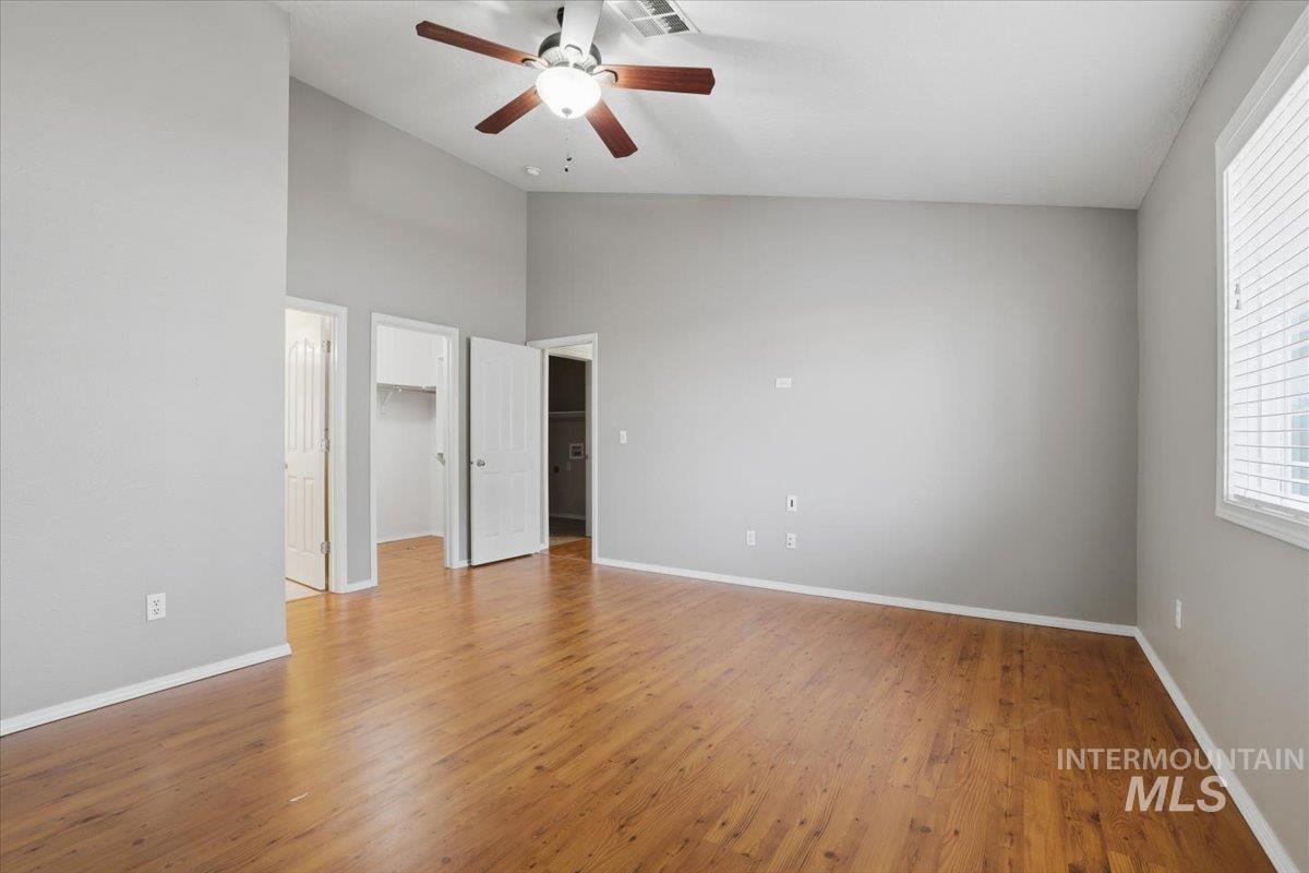 3273 North Chatterton Way Boise, ID 83713 - Photo 17 of 29 Master bedroom with a walk in closet, light wood finished floors, ceiling fan, and vaulted ceiling
