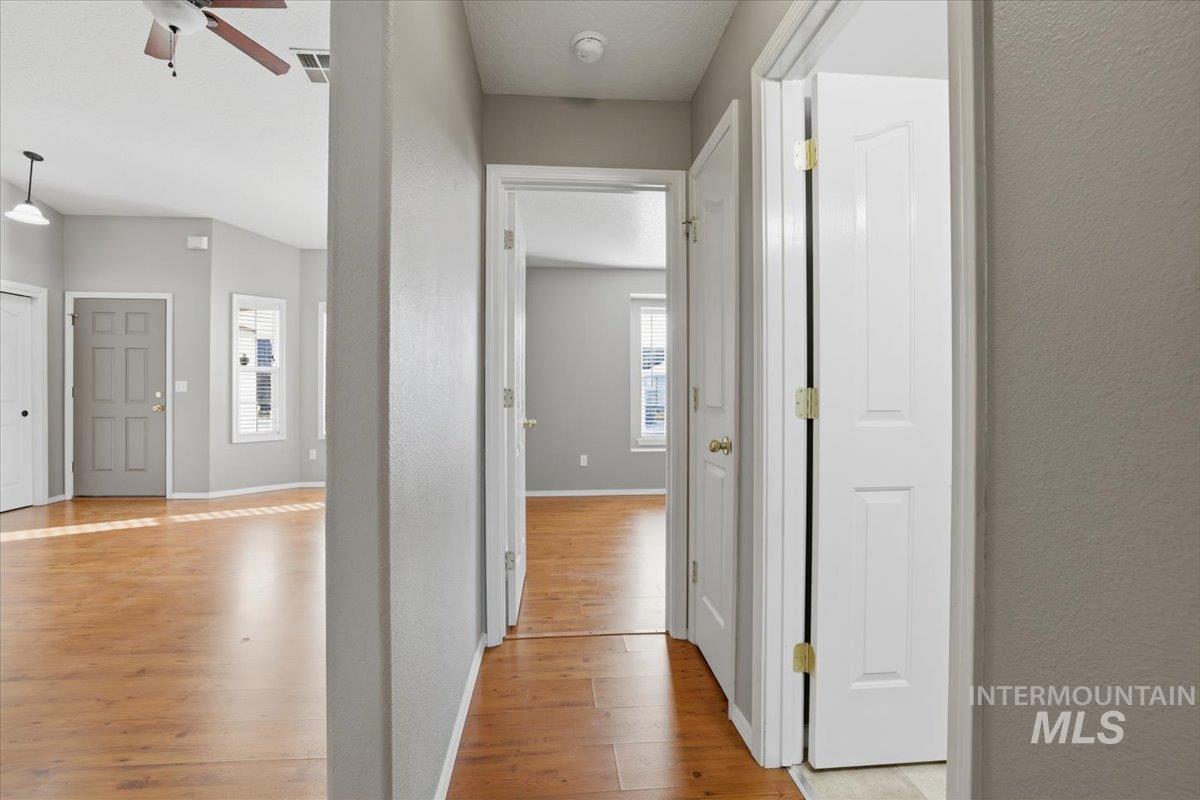 3273 North Chatterton Way Boise, ID 83713 - Photo 20 of 29 Hallway with light wood finished floors, a textured wall, and a textured ceiling