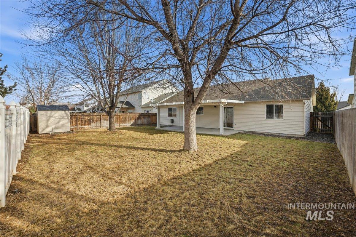 3273 North Chatterton Way Boise, ID 83713 - Photo 27 of 29 Back of property with a patio, a storage unit, and a fenced backyard