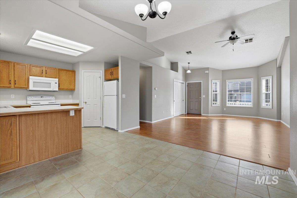 3273 North Chatterton Way Boise, ID 83713 - Photo 29 of 29 Kitchen with light countertops, a peninsula, open floor plan, white appliances, and light tile patterned flooring