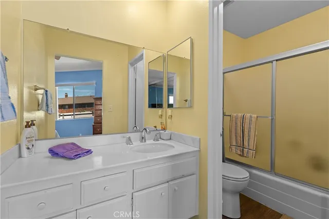a bathroom with a sink toilet vanity and shower