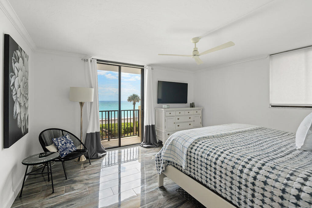 300 Ocean Trail Way, Unit 301 Jupiter, FL 33477 - Photo 21 of 64 a bedroom with a bed and a tv on the dresser