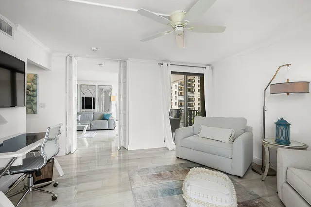 a living room with couches and kitchen view with wooden floor