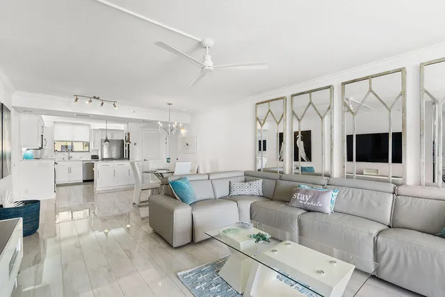 a living room with furniture a flat screen tv and a floor to ceiling window