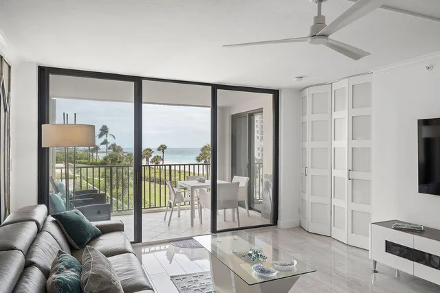 a kitchen with stainless steel appliances granite countertop a sink a stove a refrigerator and white cabinets