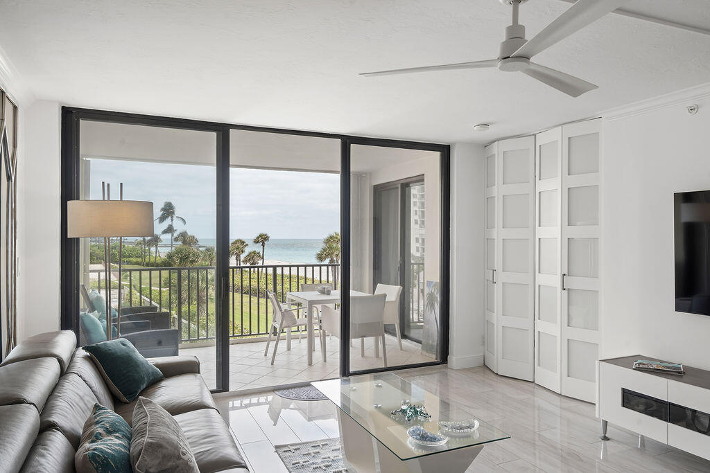 300 Ocean Trail Way, Unit 301 Jupiter, FL 33477 - Photo 8 of 64 a living room with furniture and a floor to ceiling window