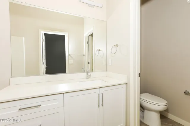 a bathroom with a sink a toilet and a mirror