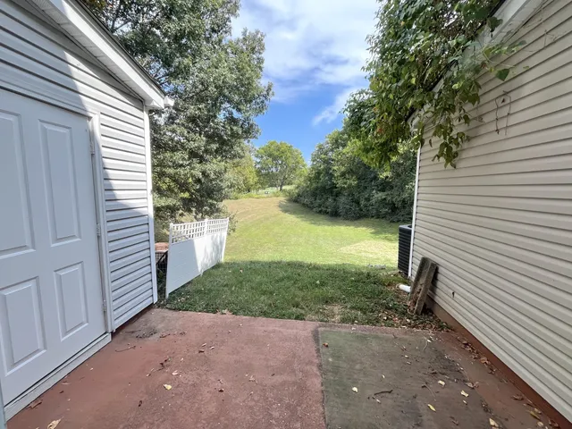 a view of a backyard with plants and a garage